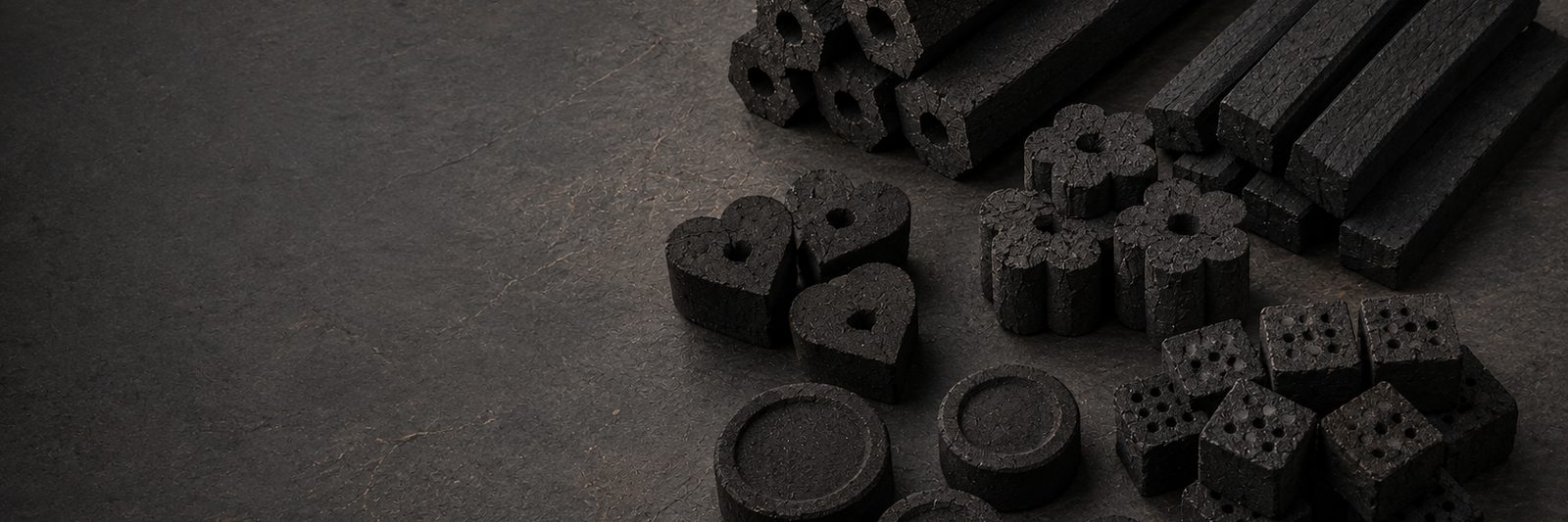 Machine-made charcoal briquettes stacked on drying racks in the factory